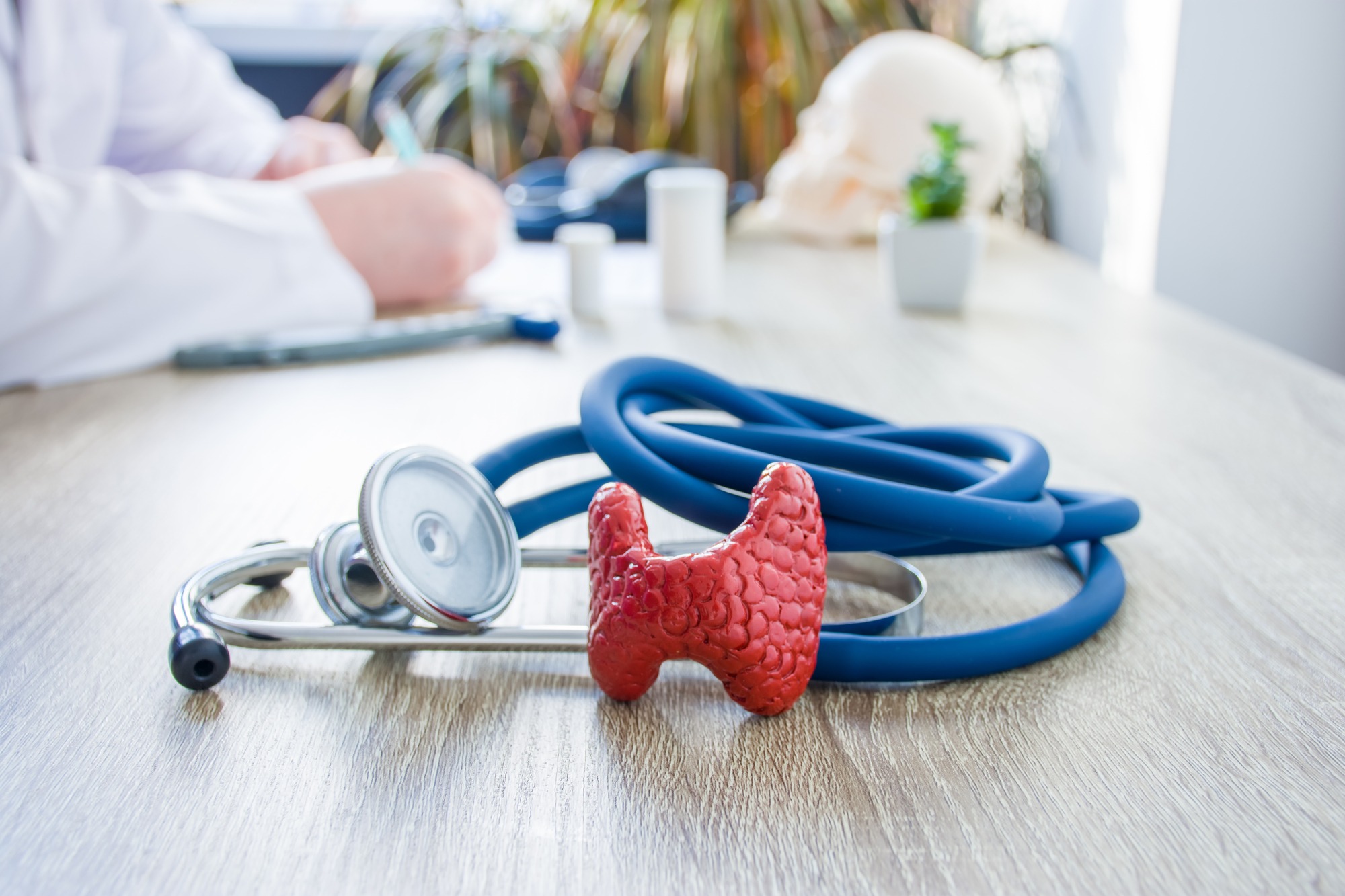 On a table, a stethoscope and a medical device sit together, representing tools for health assessment